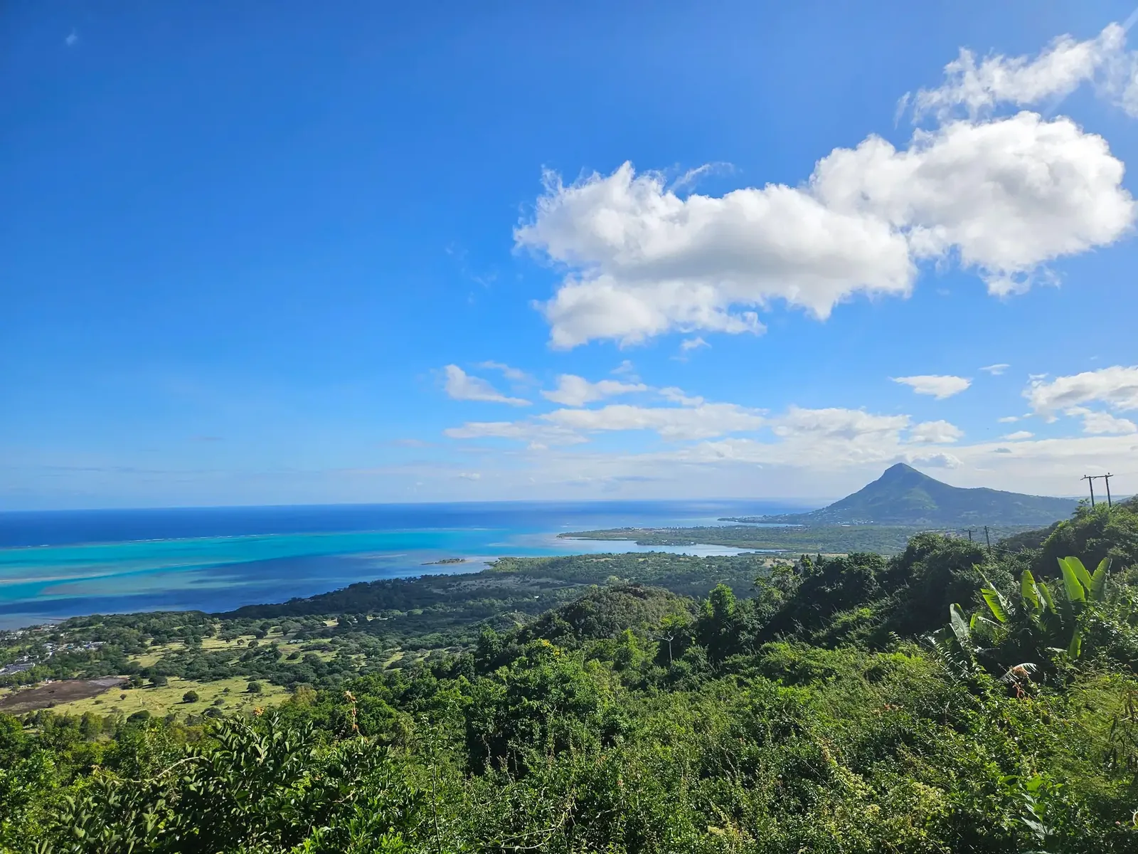 Turquoise lagoon, wooded hills and mountain scenery on the southwest coast of Mauritius.